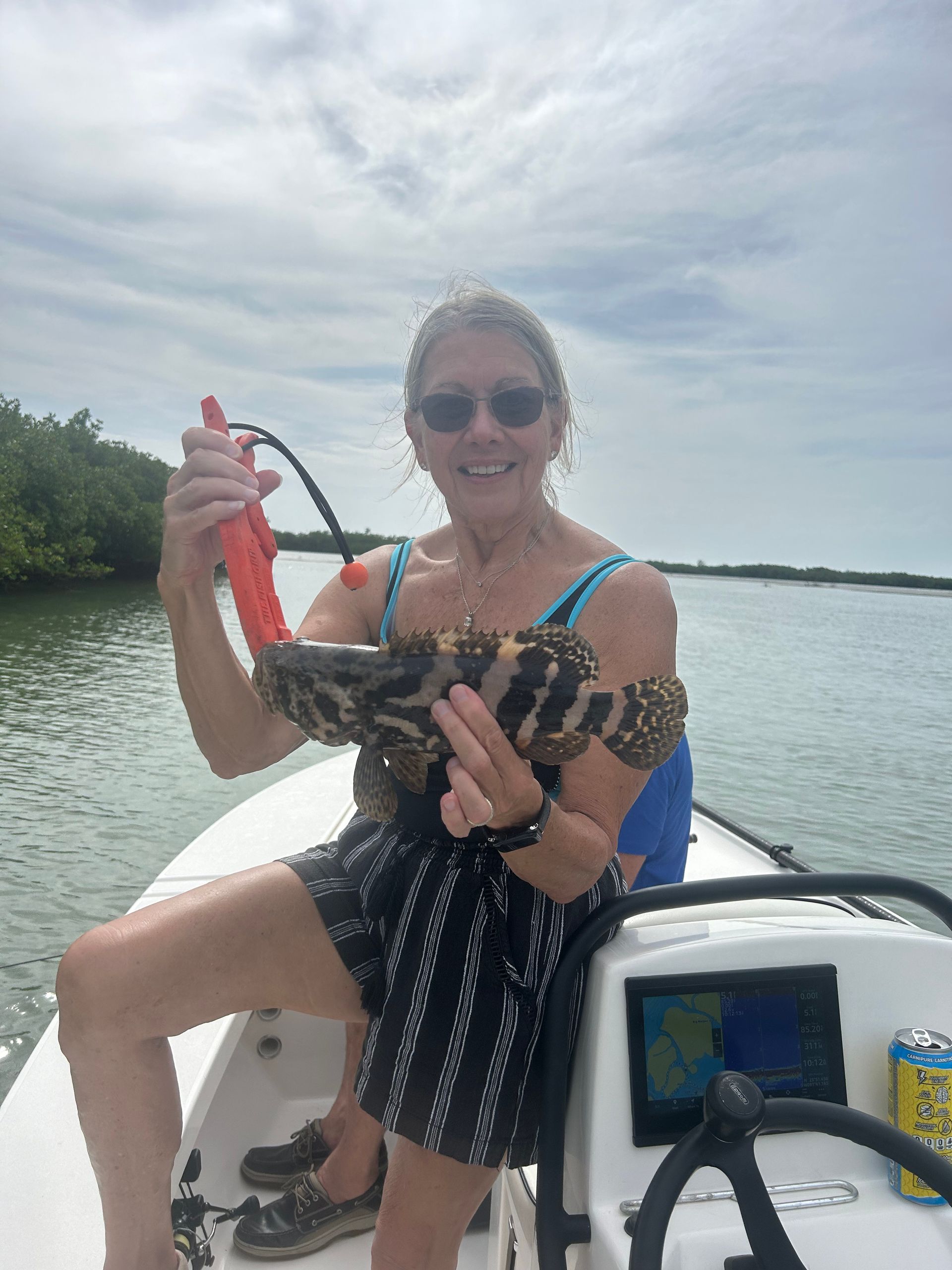 A woman is sitting on a boat holding a snake.