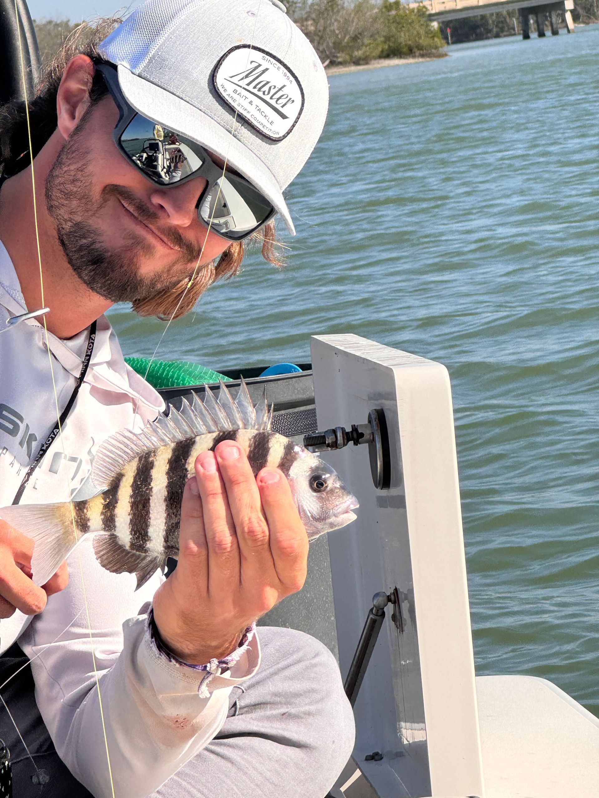 A man is holding a fish in his hands while sitting on a boat.