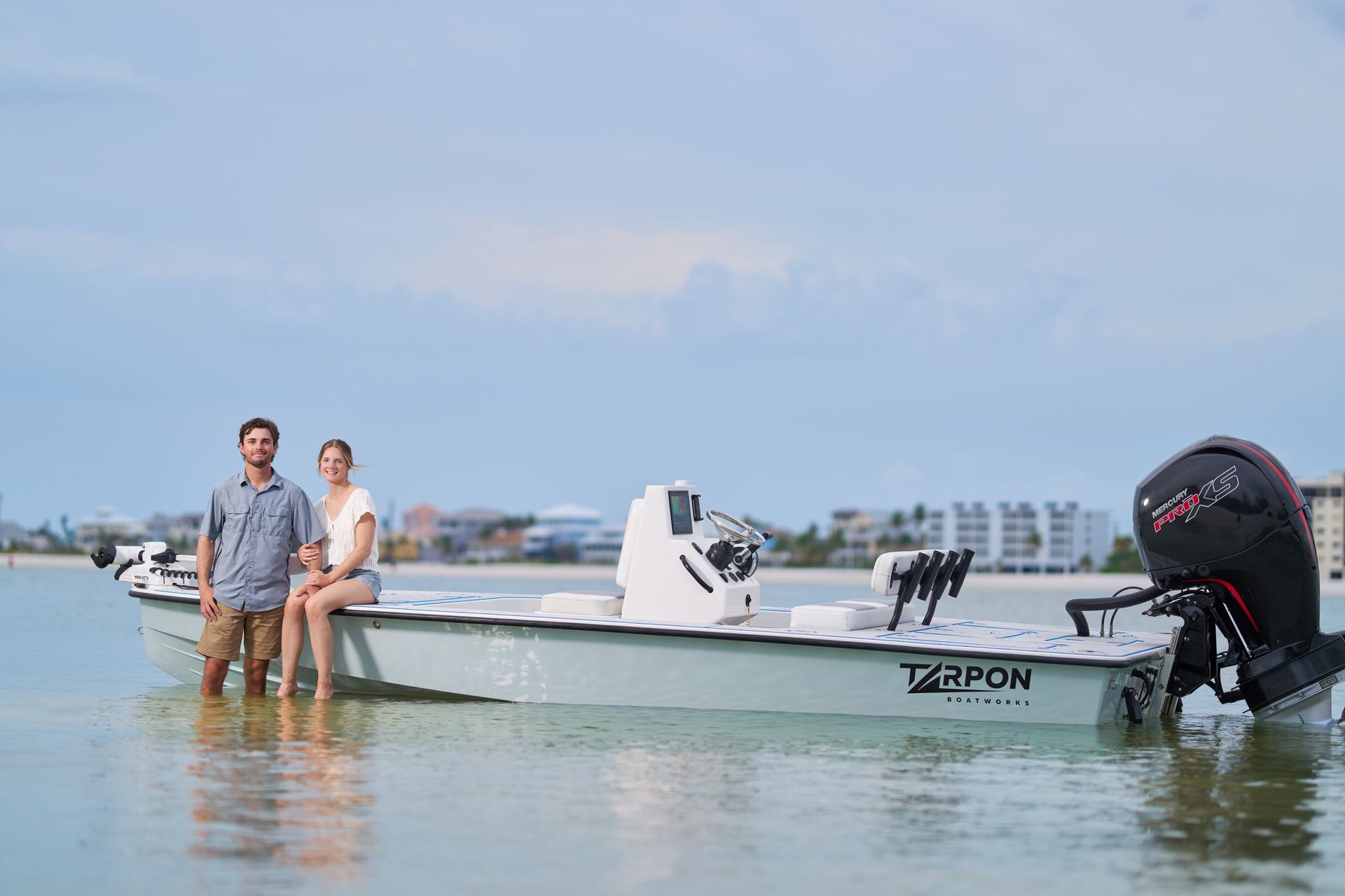Two people are standing next to a boat in the water.