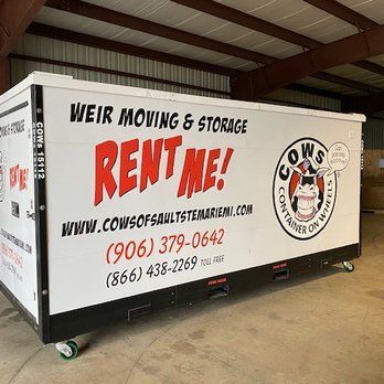 A white box with the words `` rent me '' on it is sitting in a warehouse.