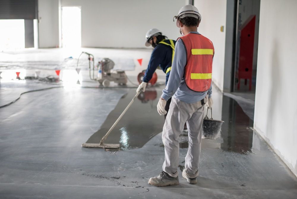 Two Construction Workers Are Working on A Concrete Floor — Slippery Solutions In Cranbrook, QLD 