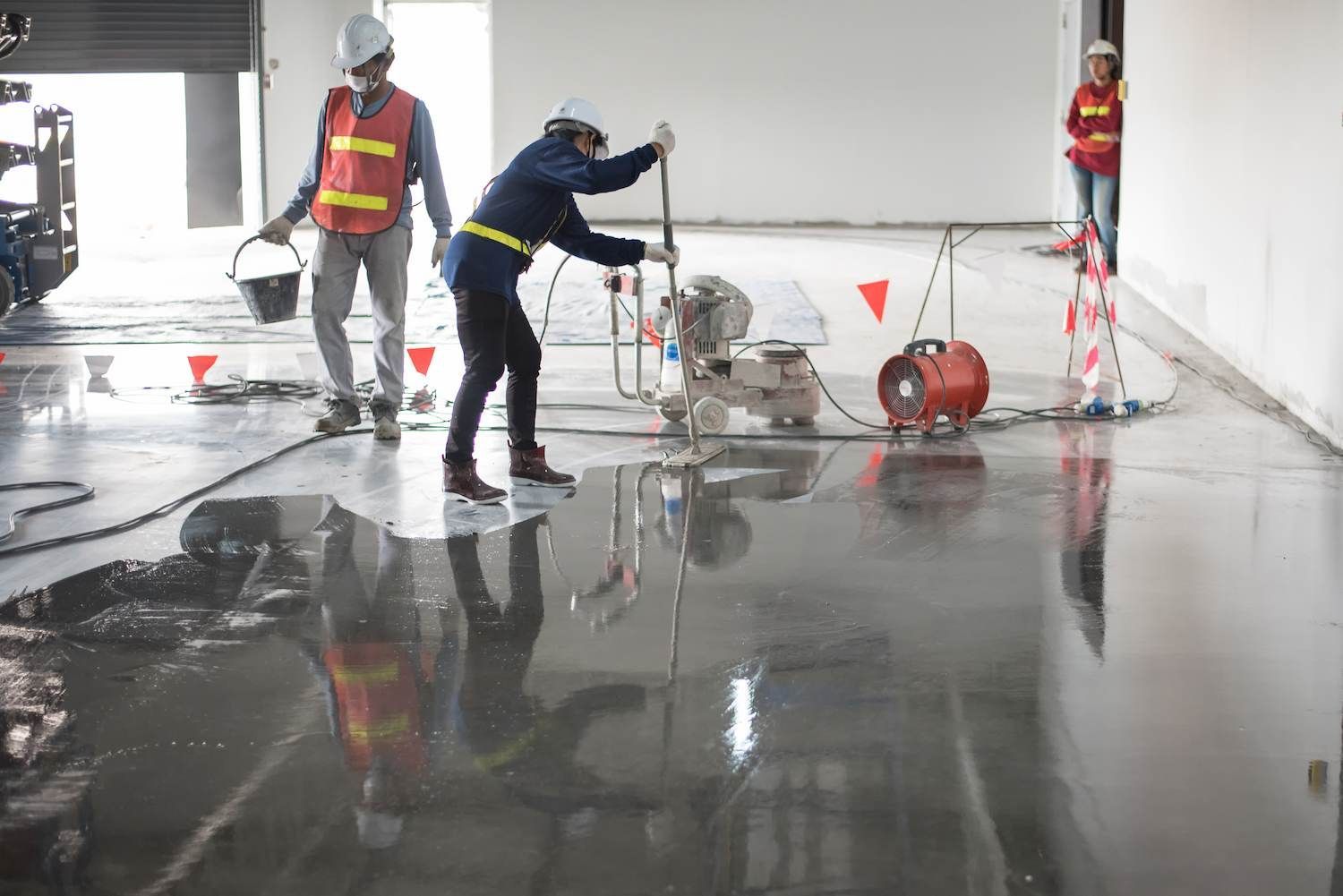 A Group of Construction Workers Are Working on A Concrete Floor — Slippery Solutions In Cranbrook, QLD 