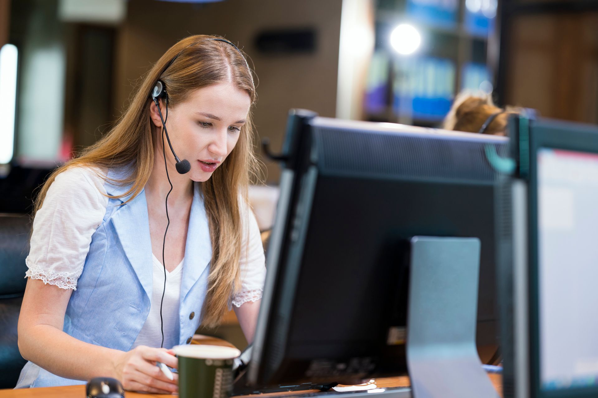 Woman with headphones focused on her computer, engaged in work related to an answering service. Woman with headphones focused on her computer, engaged in work related to an answering service.