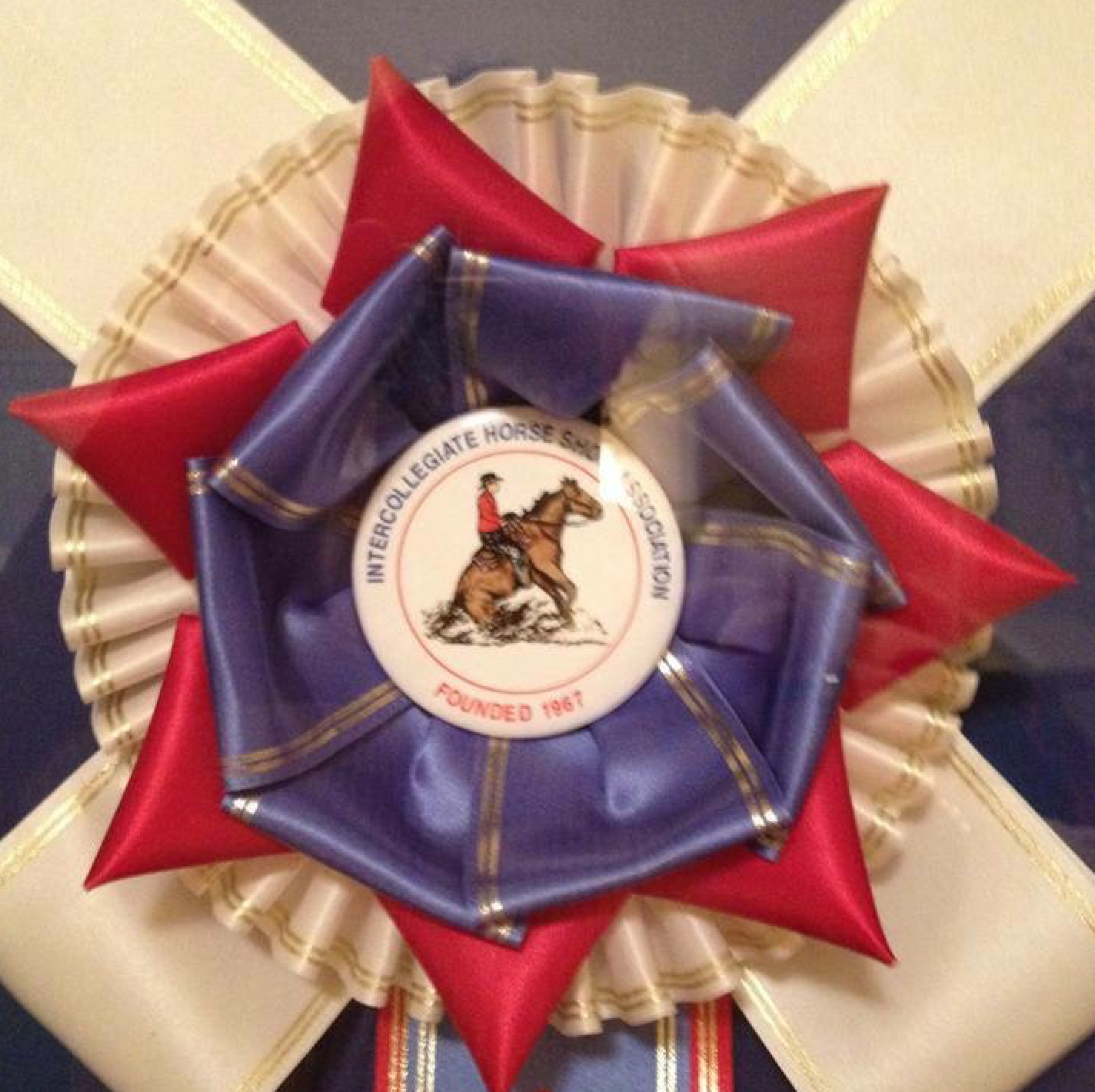 A red white and blue ribbon with a man riding a horse on it