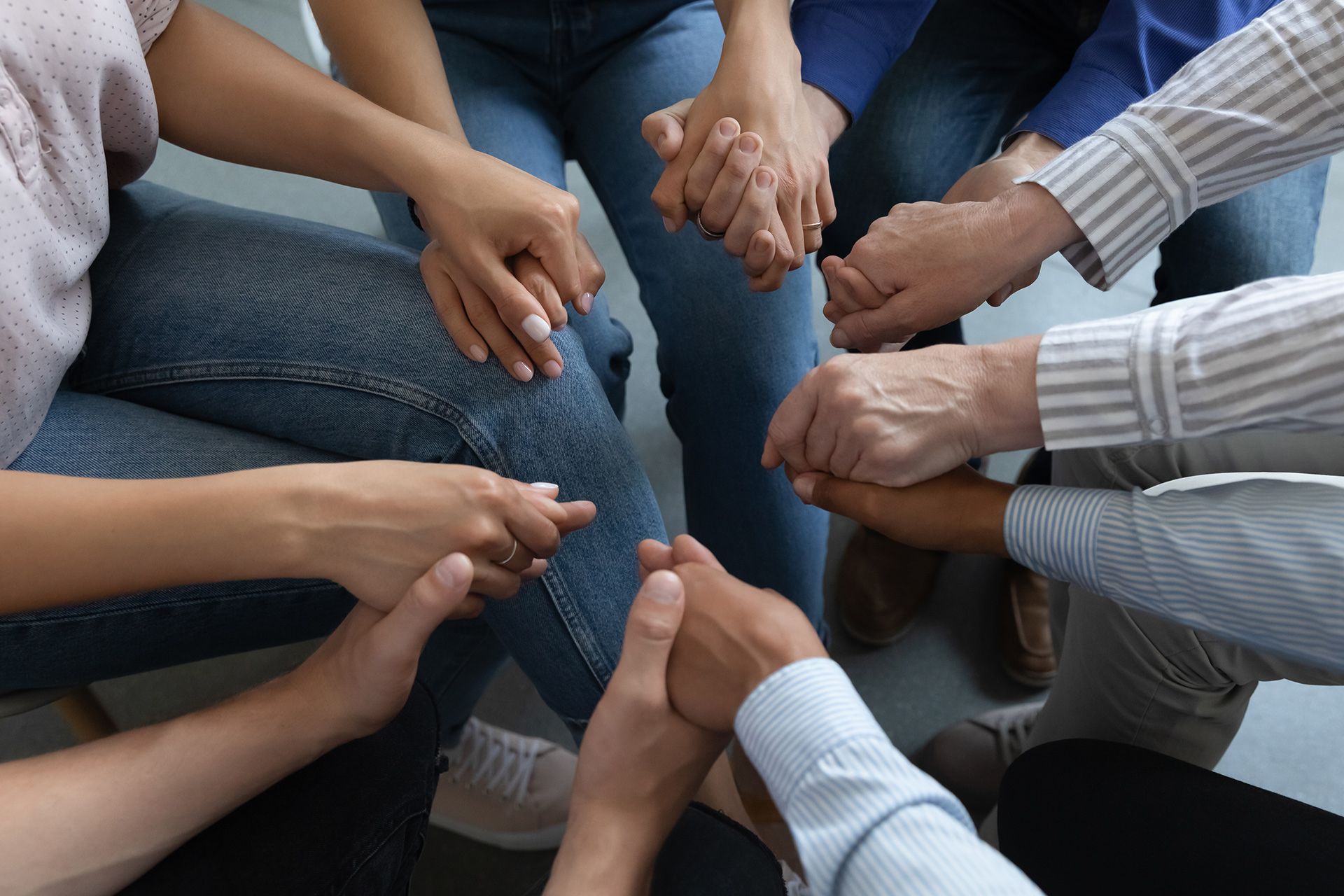 Therapist is touching the client's hand, while looking at each other. Light and airy room.