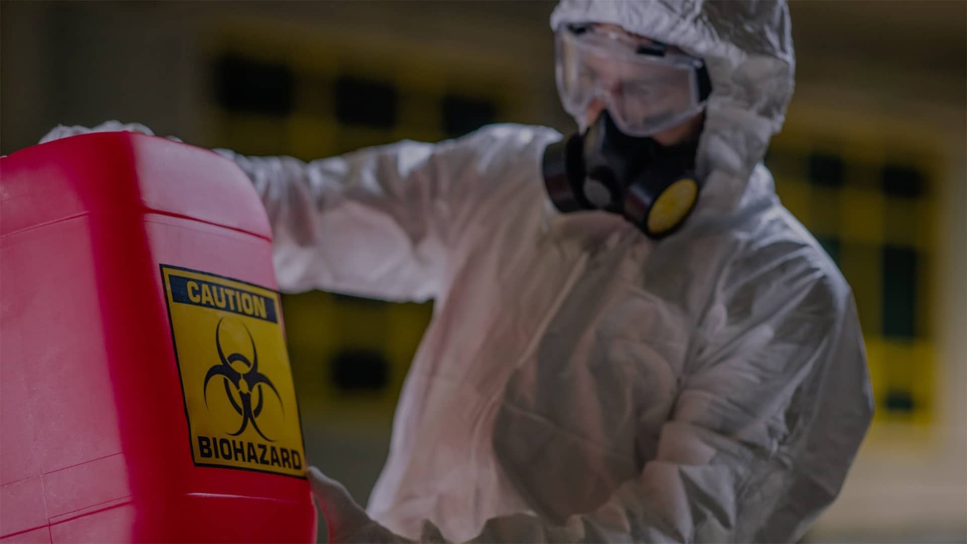 Restoration worker carrying biohazard waste can.