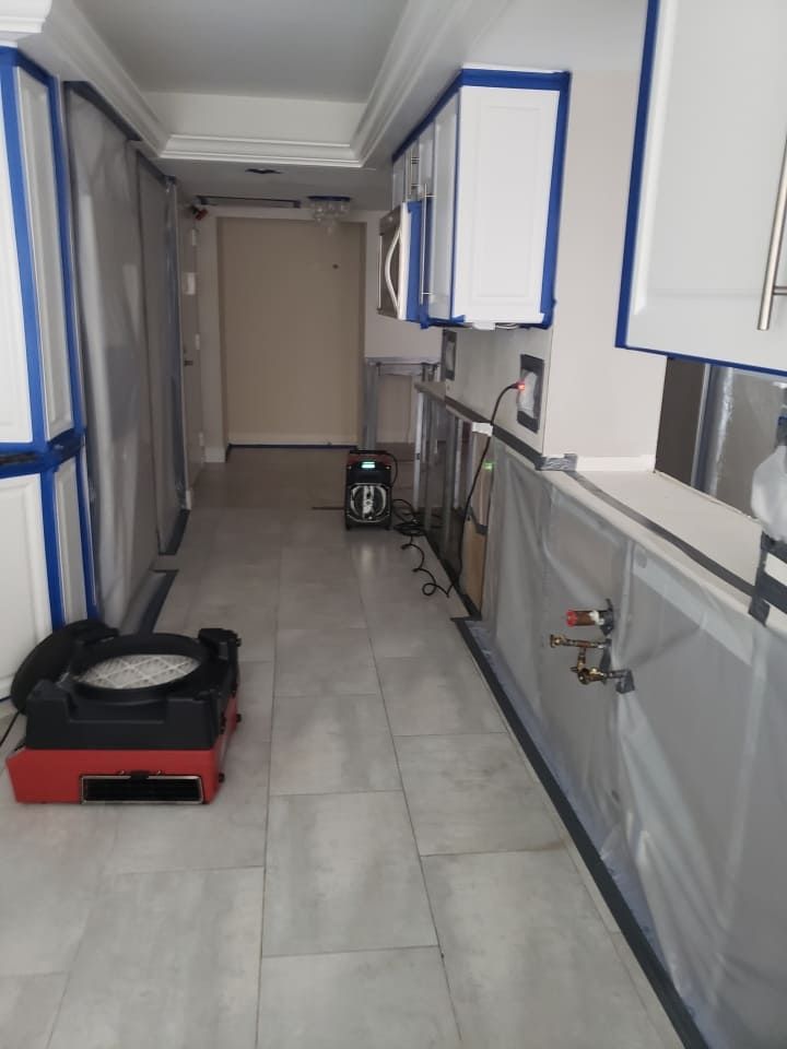 Close-up of mold remediation and cleanup process inside kitchen walls during Fort Myers restoration project.
