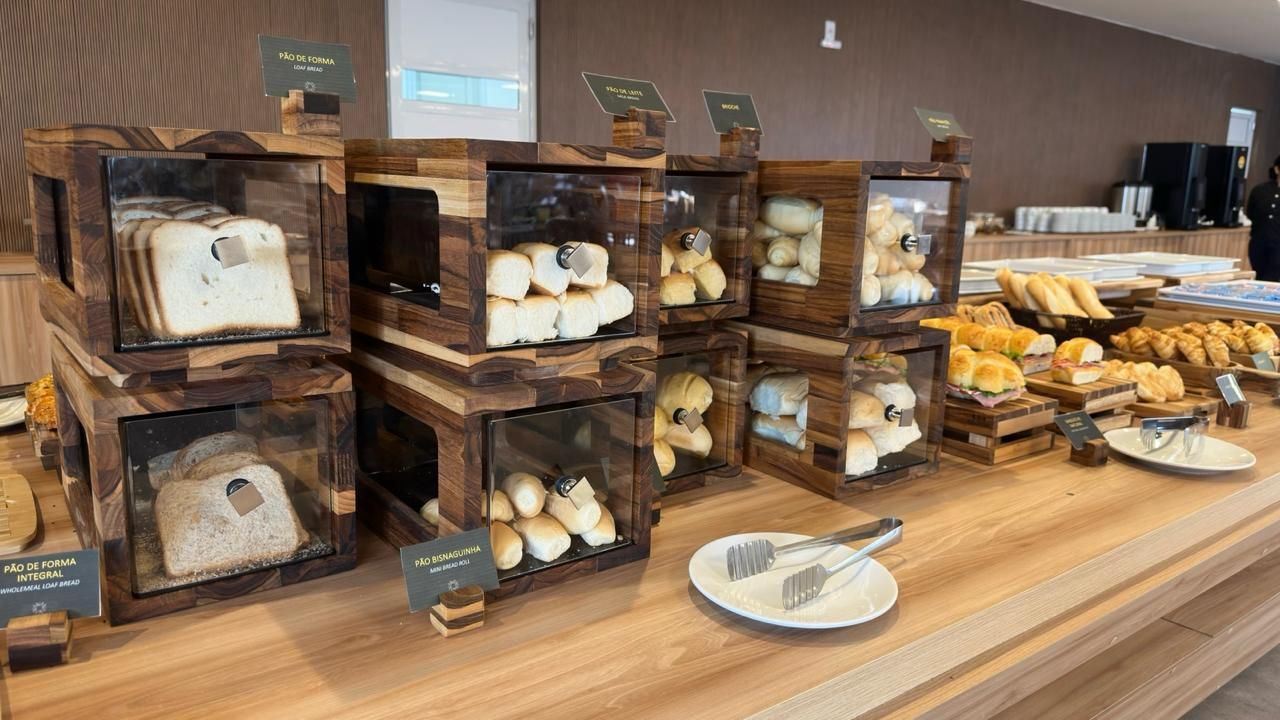Vitrine de madeira para pães, com diversos tipos de pães e pãezinhos.