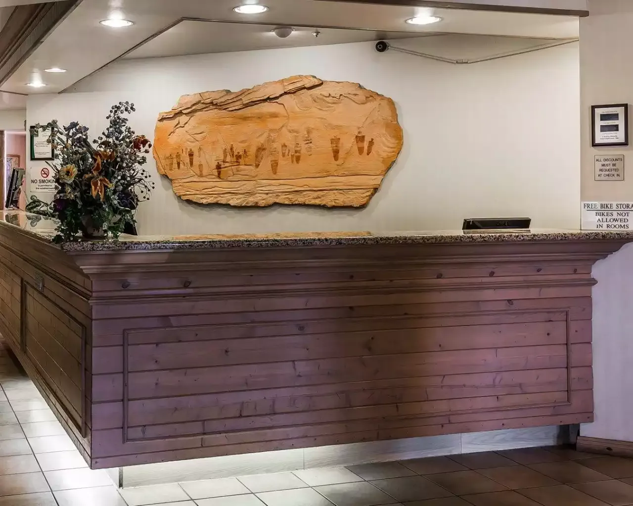 A hotel lobby with a wooden counter and a painting on the wall
