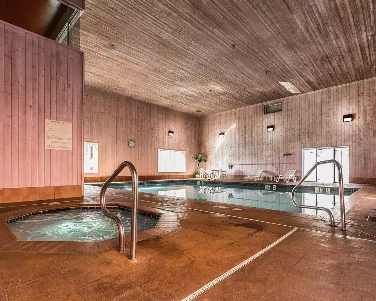 A large indoor swimming pool with a hot tub in the middle.