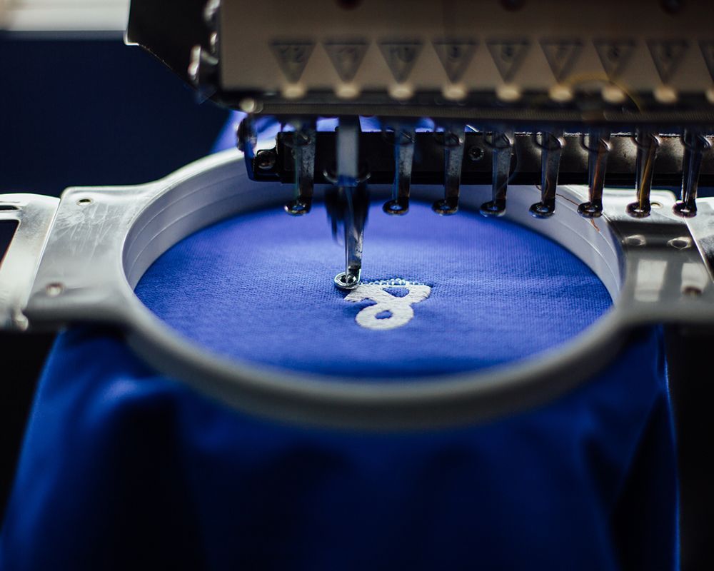 Embroidery Machine Head with Blue Fabric — Grand Junction, CO — Hi Fashion Sewing Machines