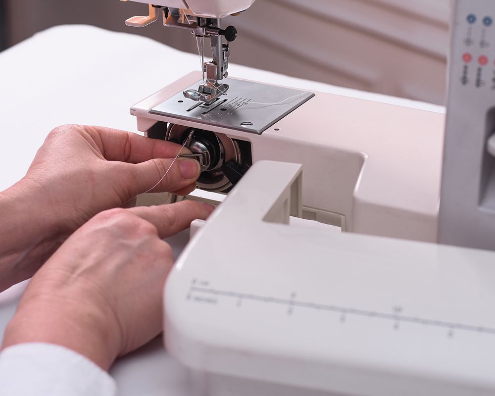Woman Inserting the Thread into the Sewing Machine — Grand Junction, CO — Hi Fashion Sewing Machines