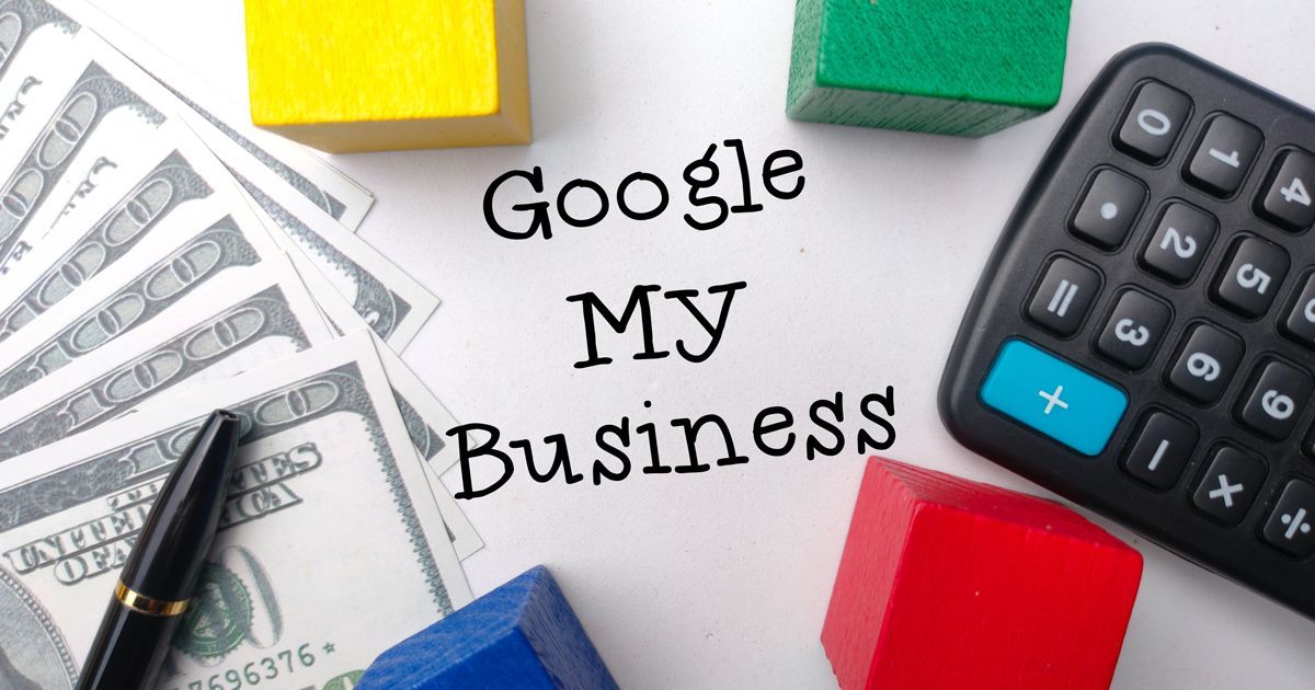 A calculator , money , and wooden blocks with the words `` google my business '' written on a piece of paper.