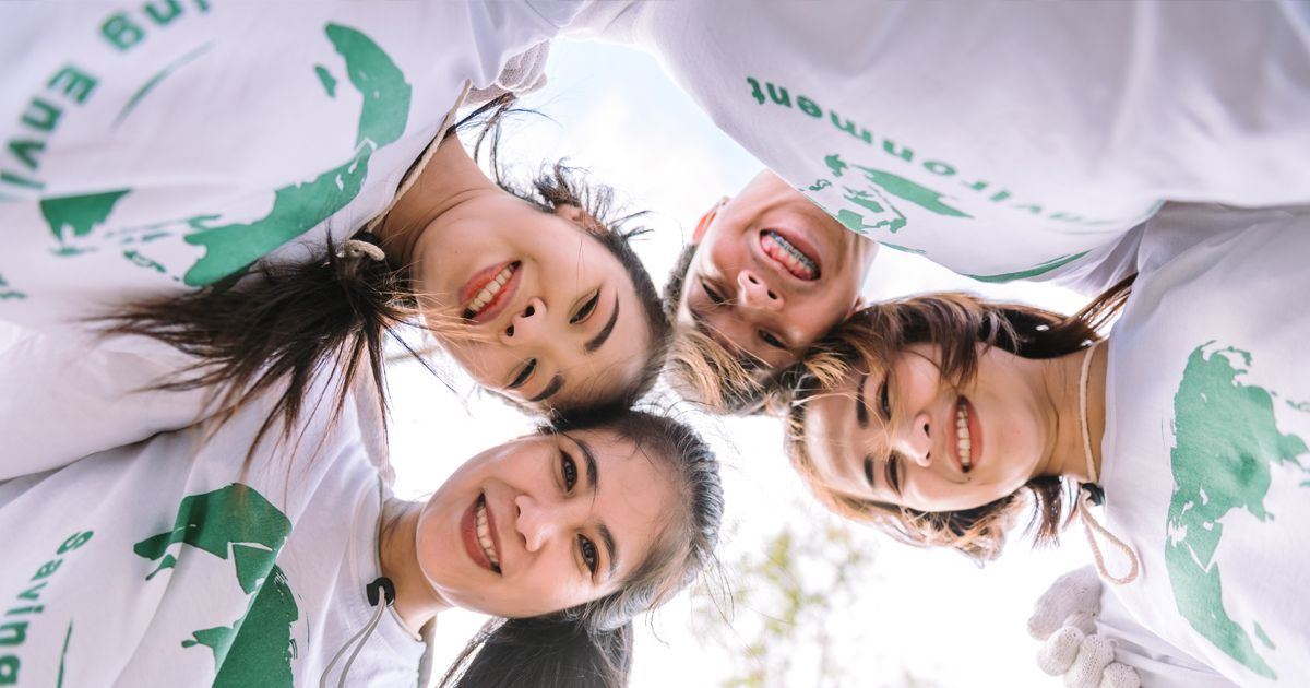 A group of people are standing in a circle with their heads together.