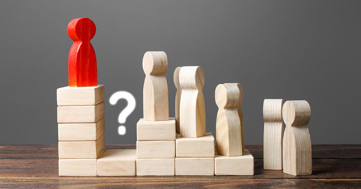 A red figure is standing on top of a staircase made of wooden blocks.