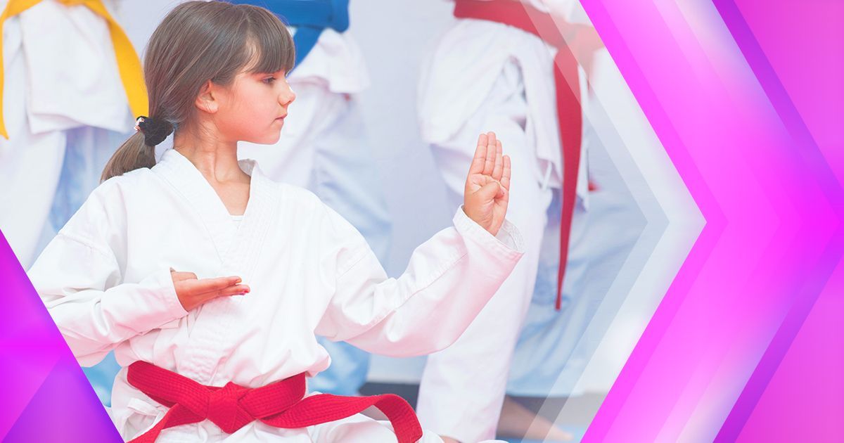 A young girl with a red belt is practicing karate in a gym.