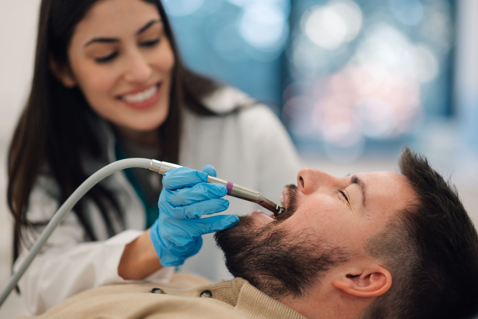 Dentist using a tool to examine a patient’s mouth during a dental checkup