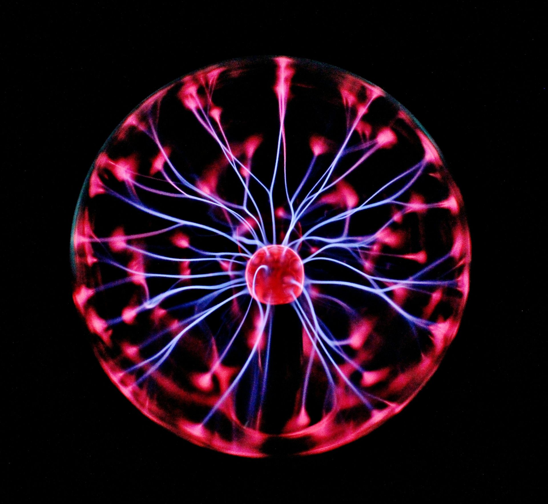 Plasma ball with red and blue electrical discharges radiating outwards from a central red sphere.