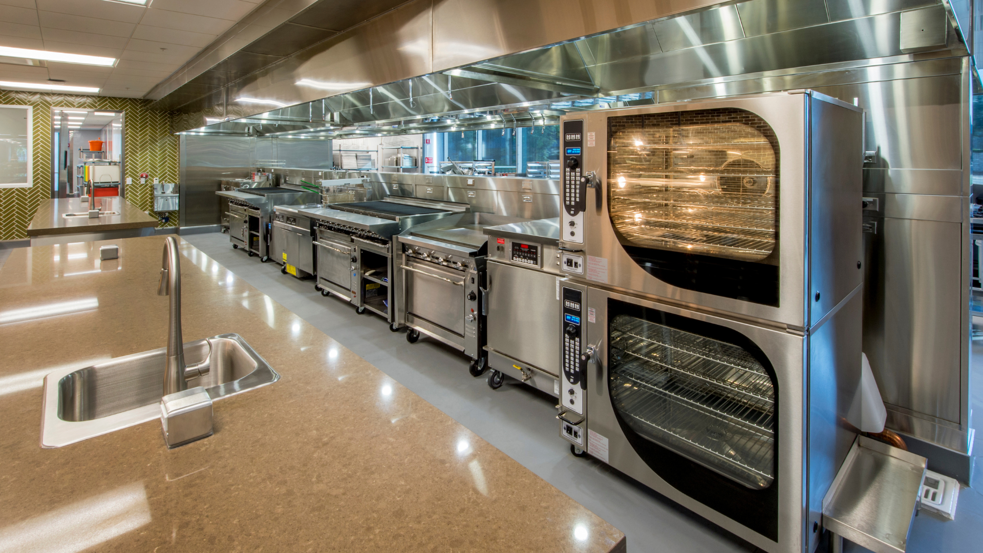 A large kitchen with a lot of stainless steel appliances.