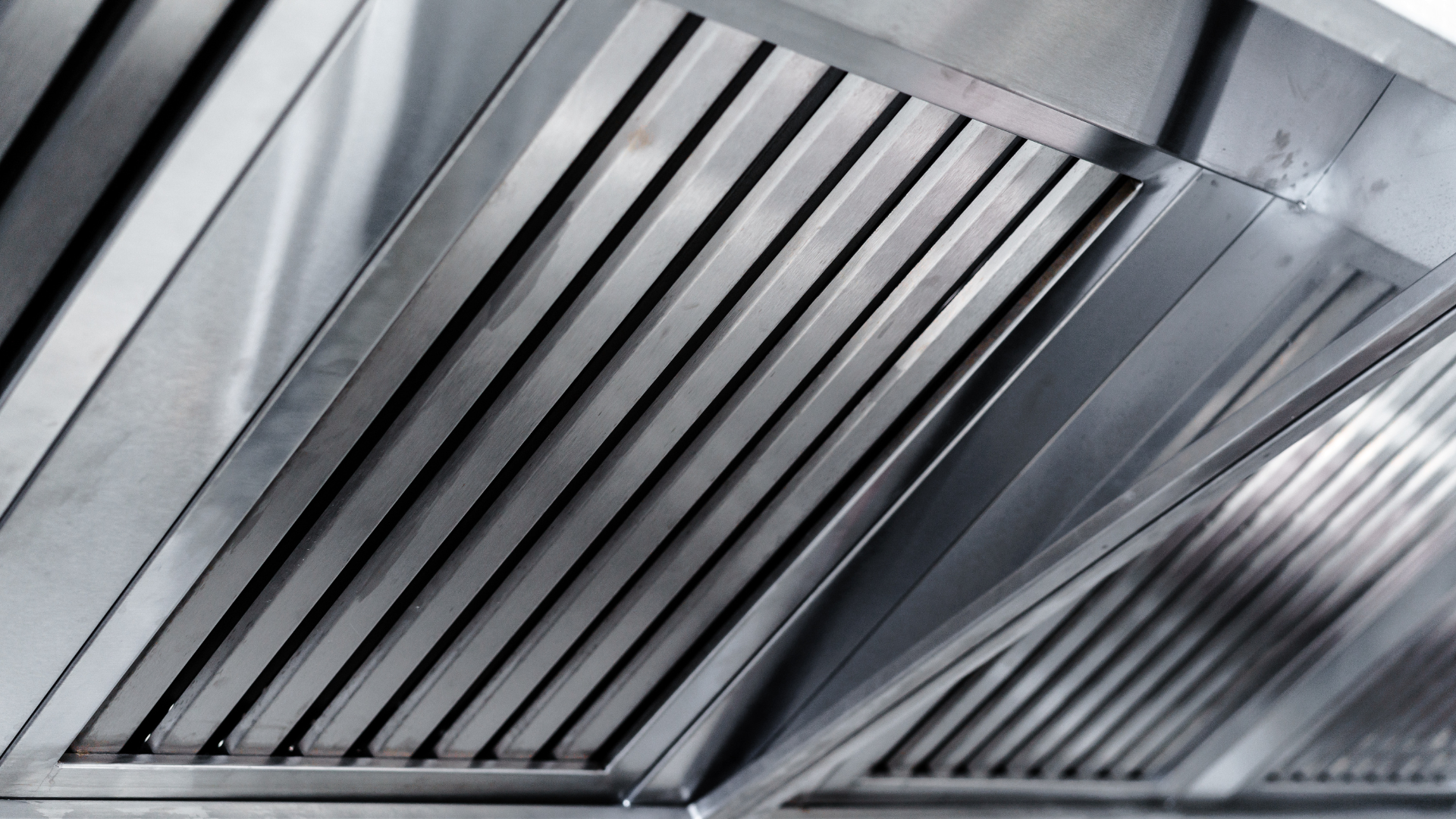 A close up of a stainless steel exhaust hood in a kitchen