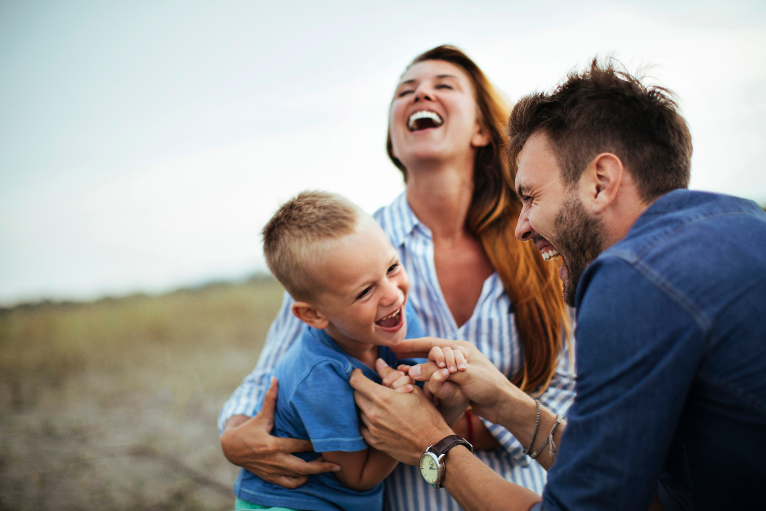 A family is smiling for a picture while sitting at a table.