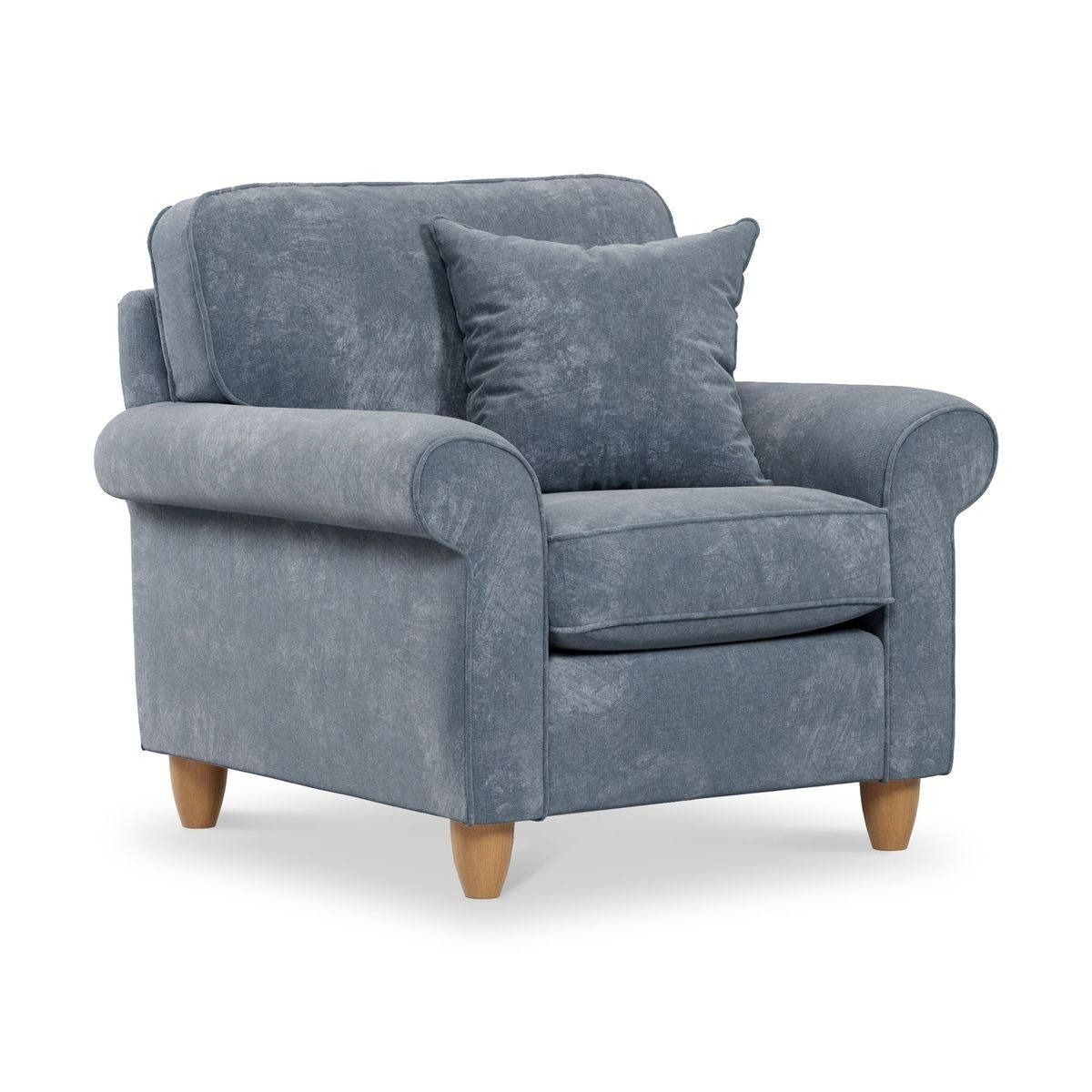 Blue upholstered armchair with a pillow on a white background.