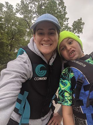 A woman and a boy are posing for a picture while wearing life jackets.