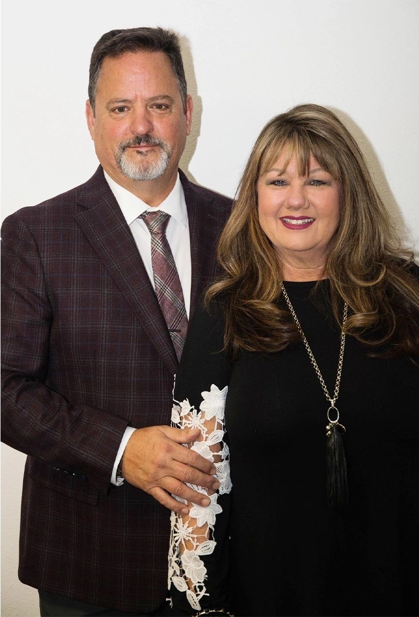 The inside of a church with rows of benches and a large window.