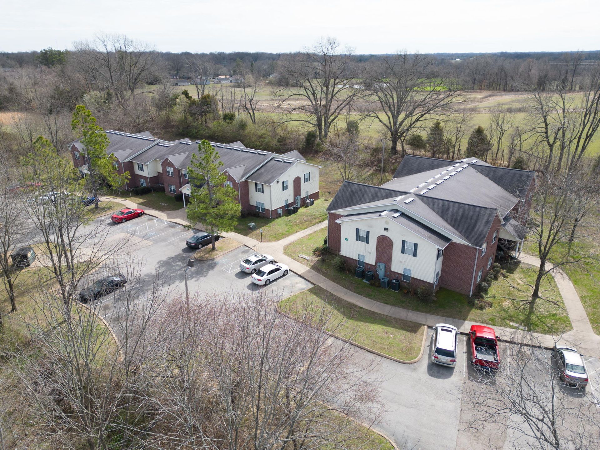 An aerial view of a row of houses with cars parked in front of them.