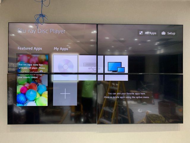 A blue ray disc player is displayed on a large screen