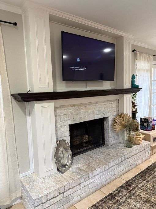 A living room with two pink chairs and a fireplace