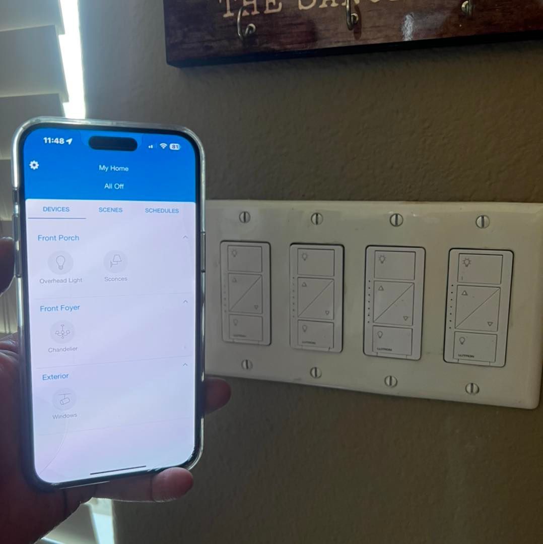 A person is holding a tablet in their hand in a living room.