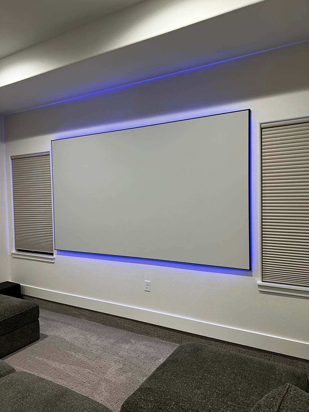 A living room with a large white screen on the wall.