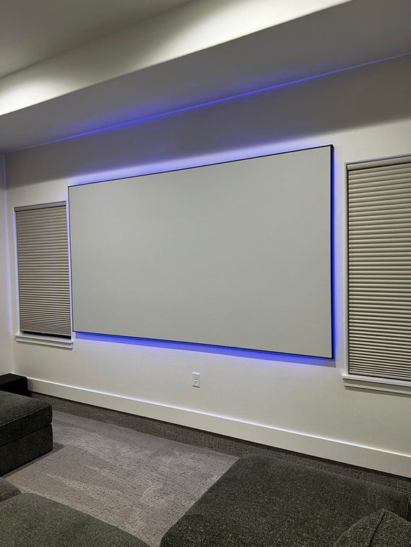 A living room with a large white screen on the wall.