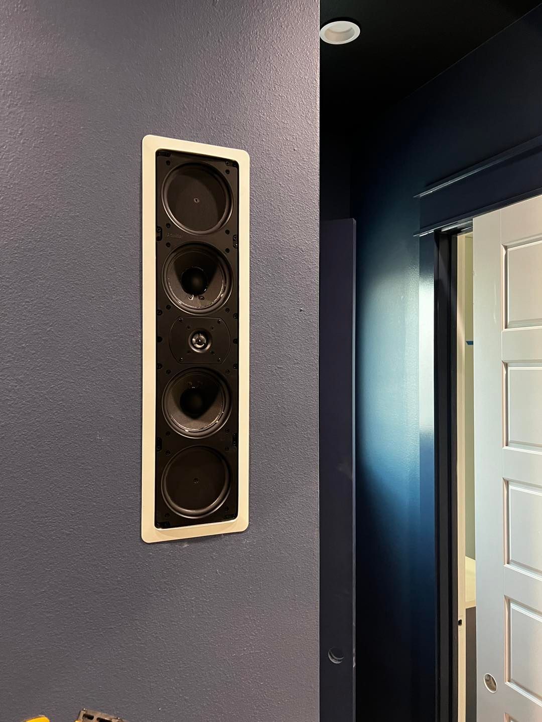 A pair of speakers mounted on a wall next to a door.