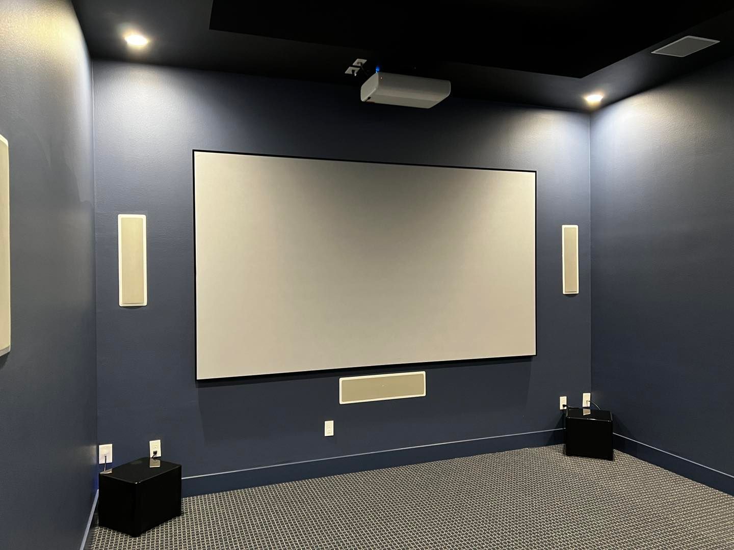 A home theater with a large screen and speakers