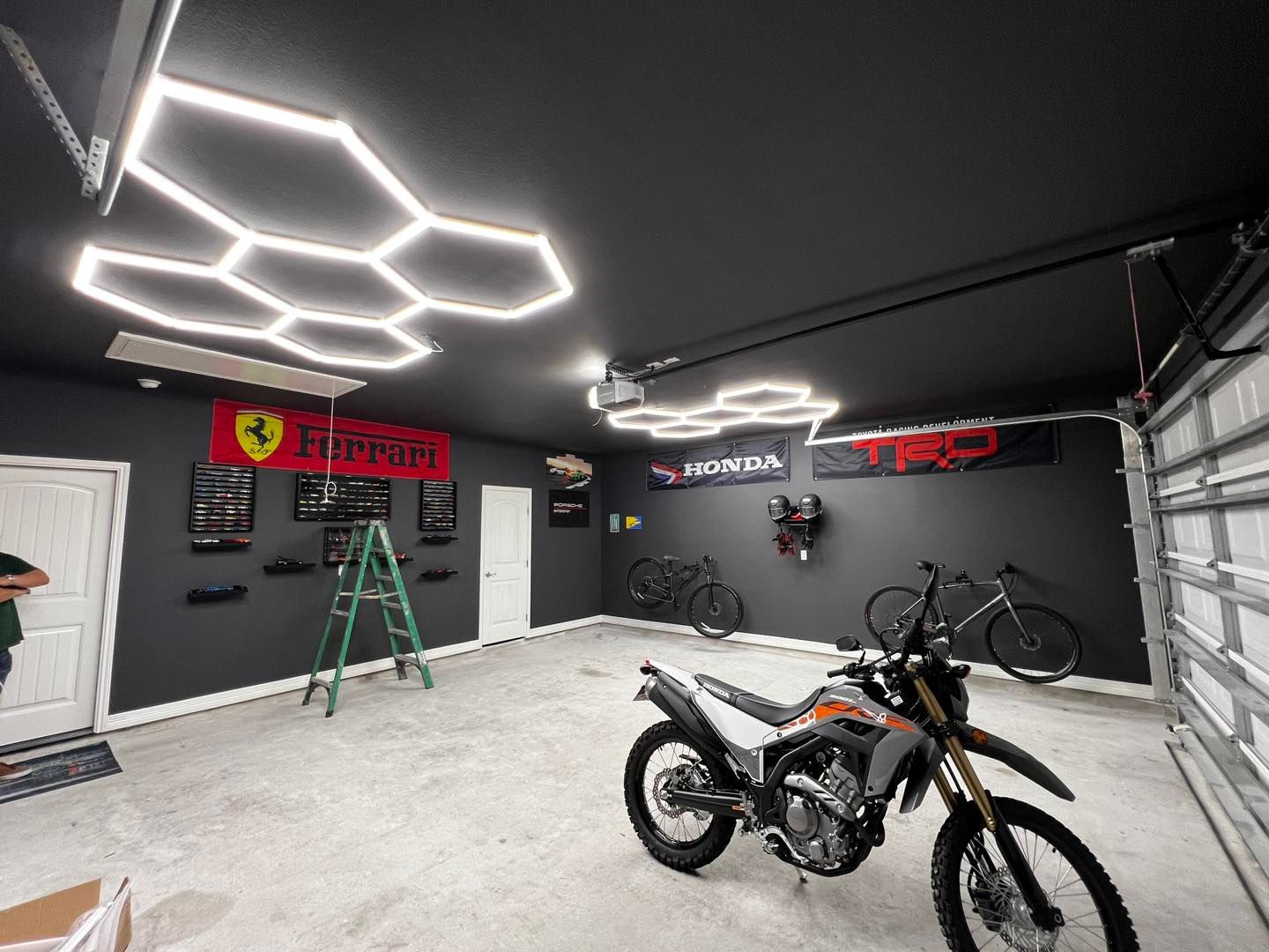 A motorcycle is parked in a garage with a ladder.