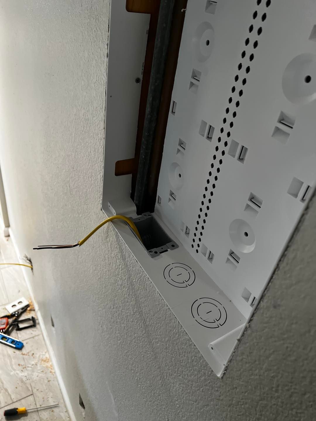 A white box with a yellow wire coming out of it.