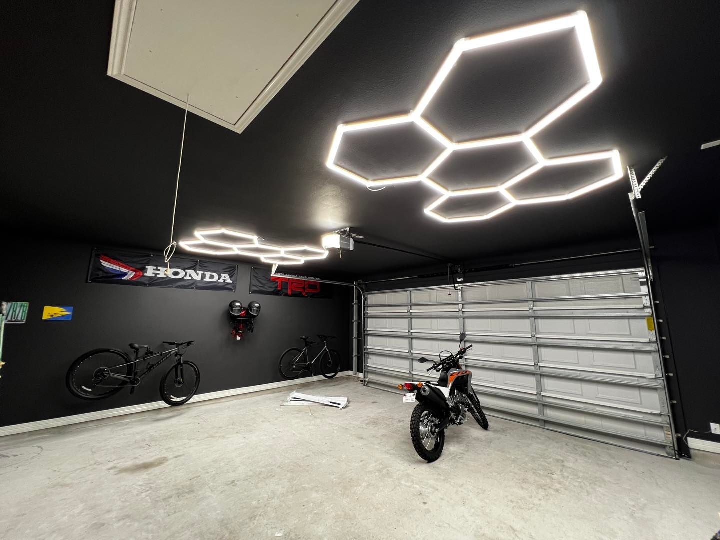 A motorcycle is parked in a garage next to a bicycle.