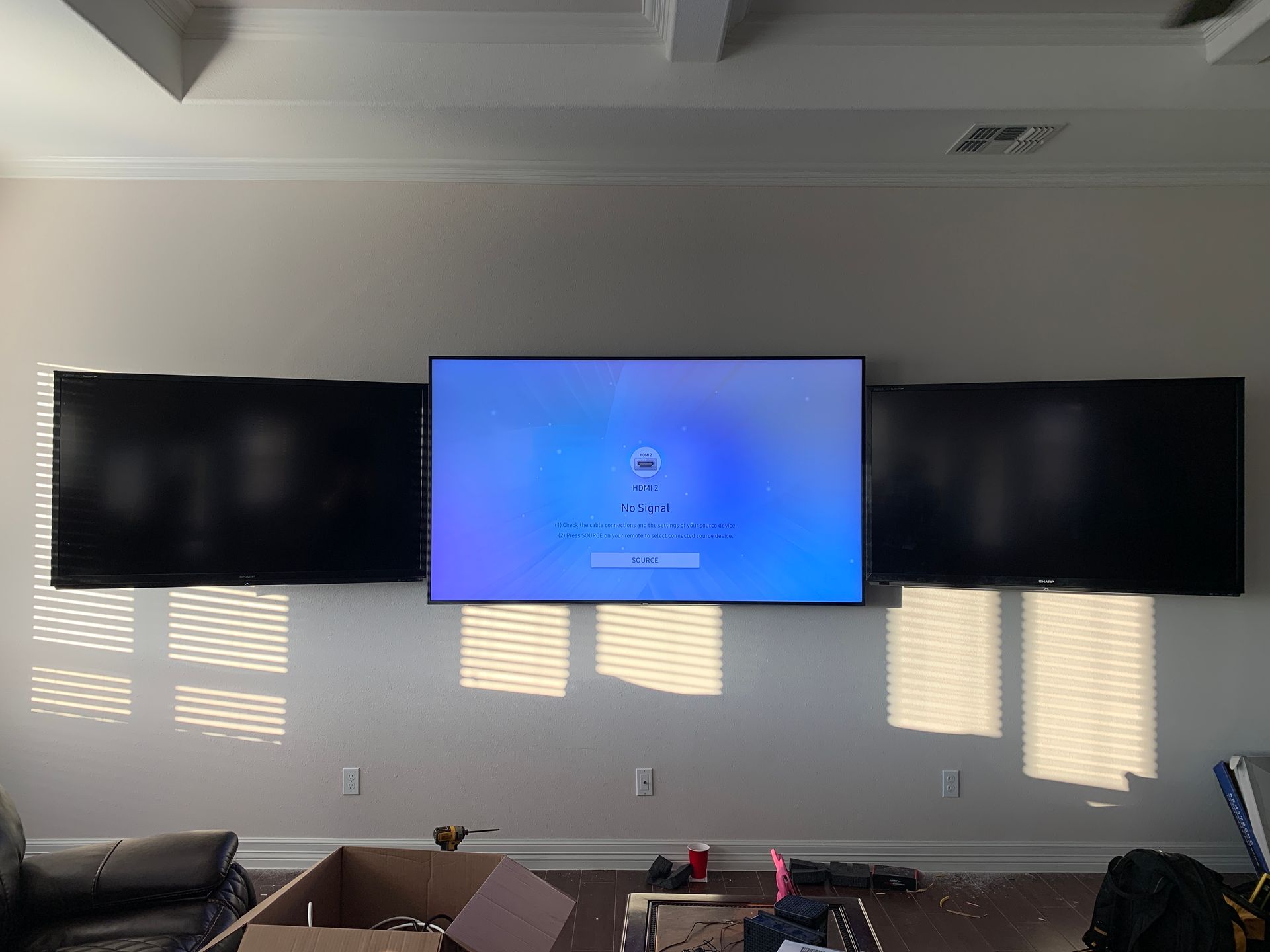 A living room with two flat screen tvs mounted to the wall.