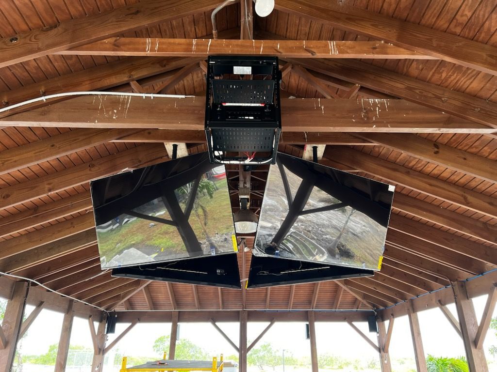 A flat screen tv is mounted on a brick wall.