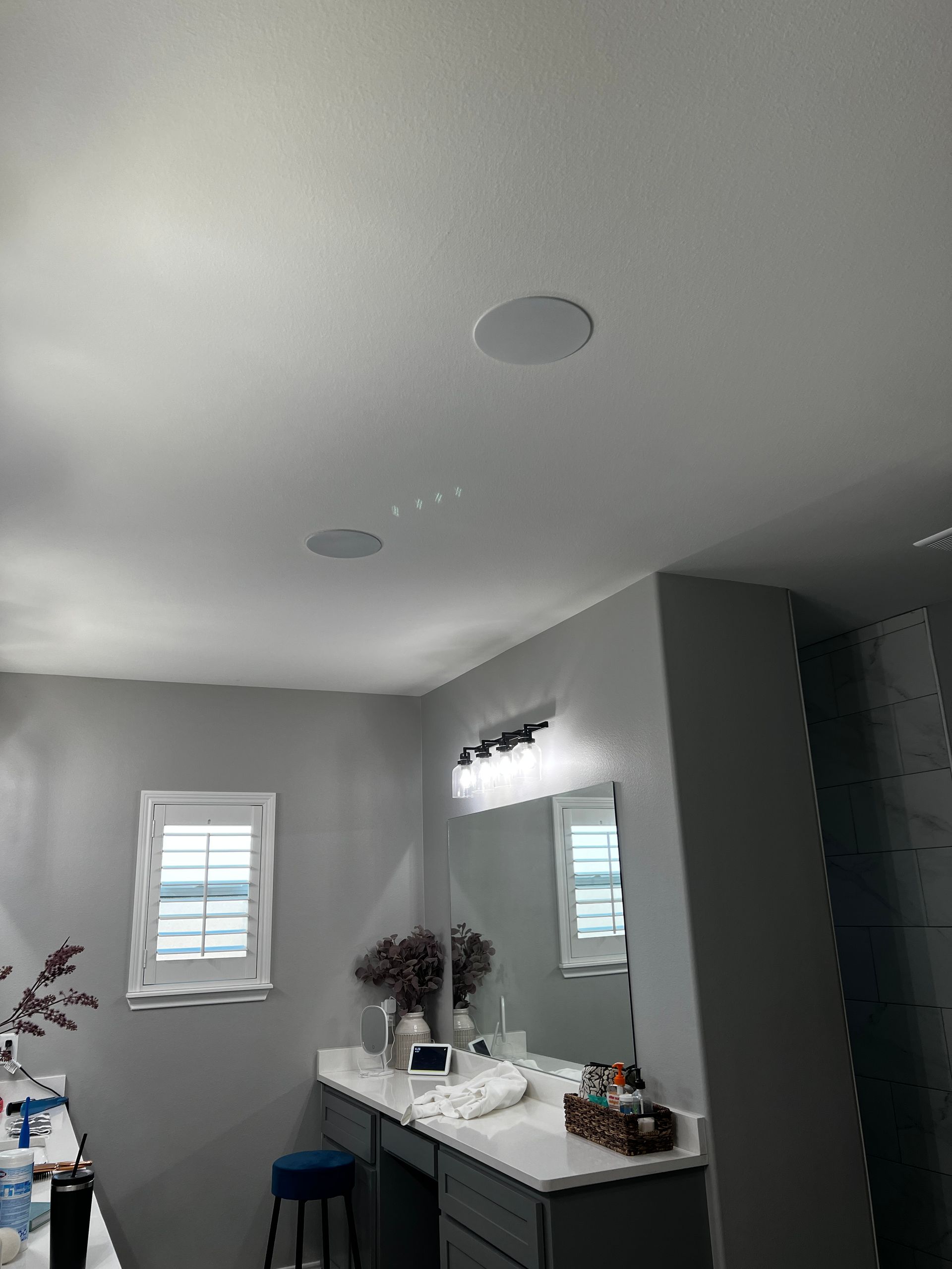 A bathroom with two sinks , a mirror , and a stool.