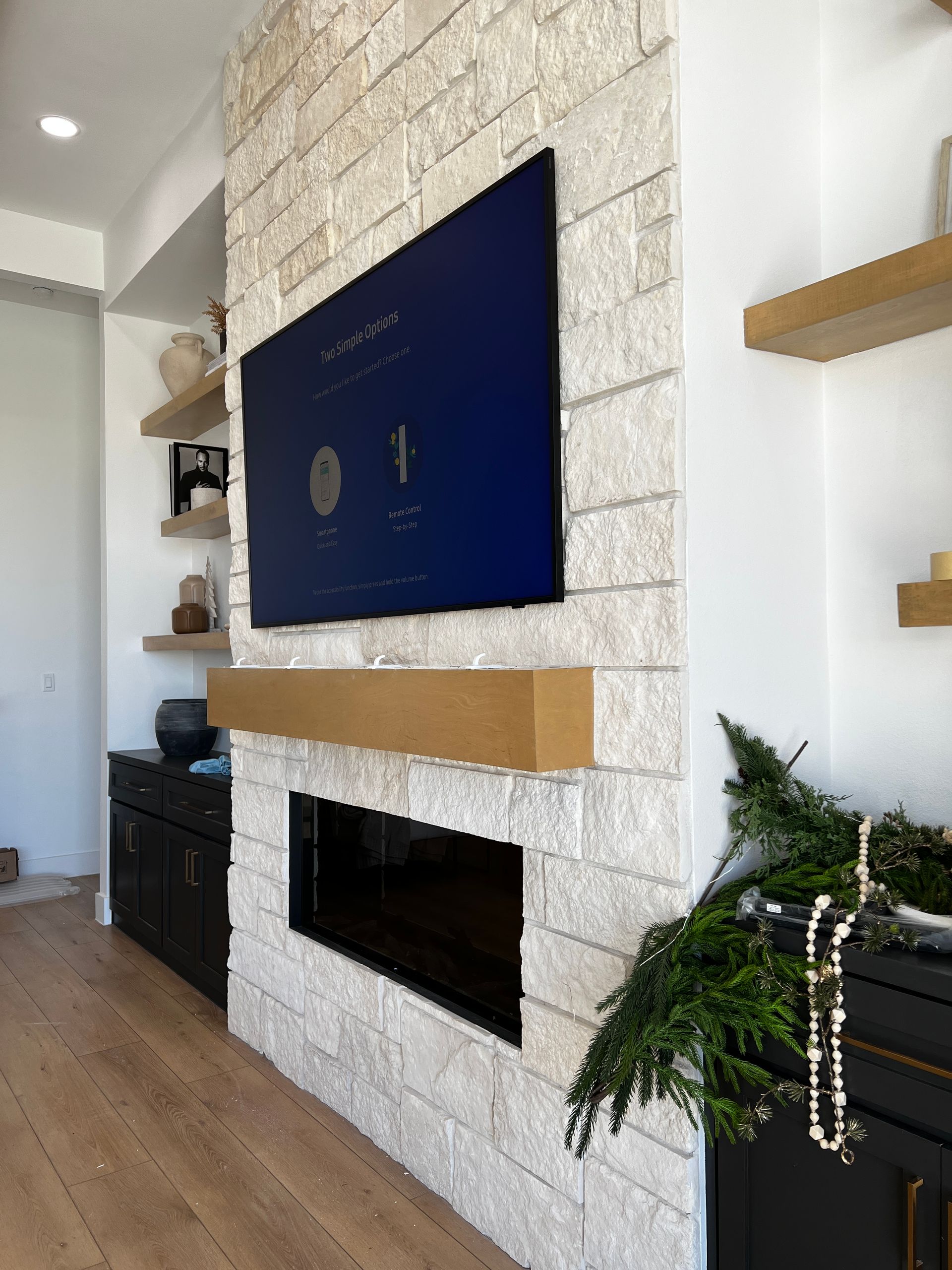 A living room with a fireplace and a flat screen tv on the wall.