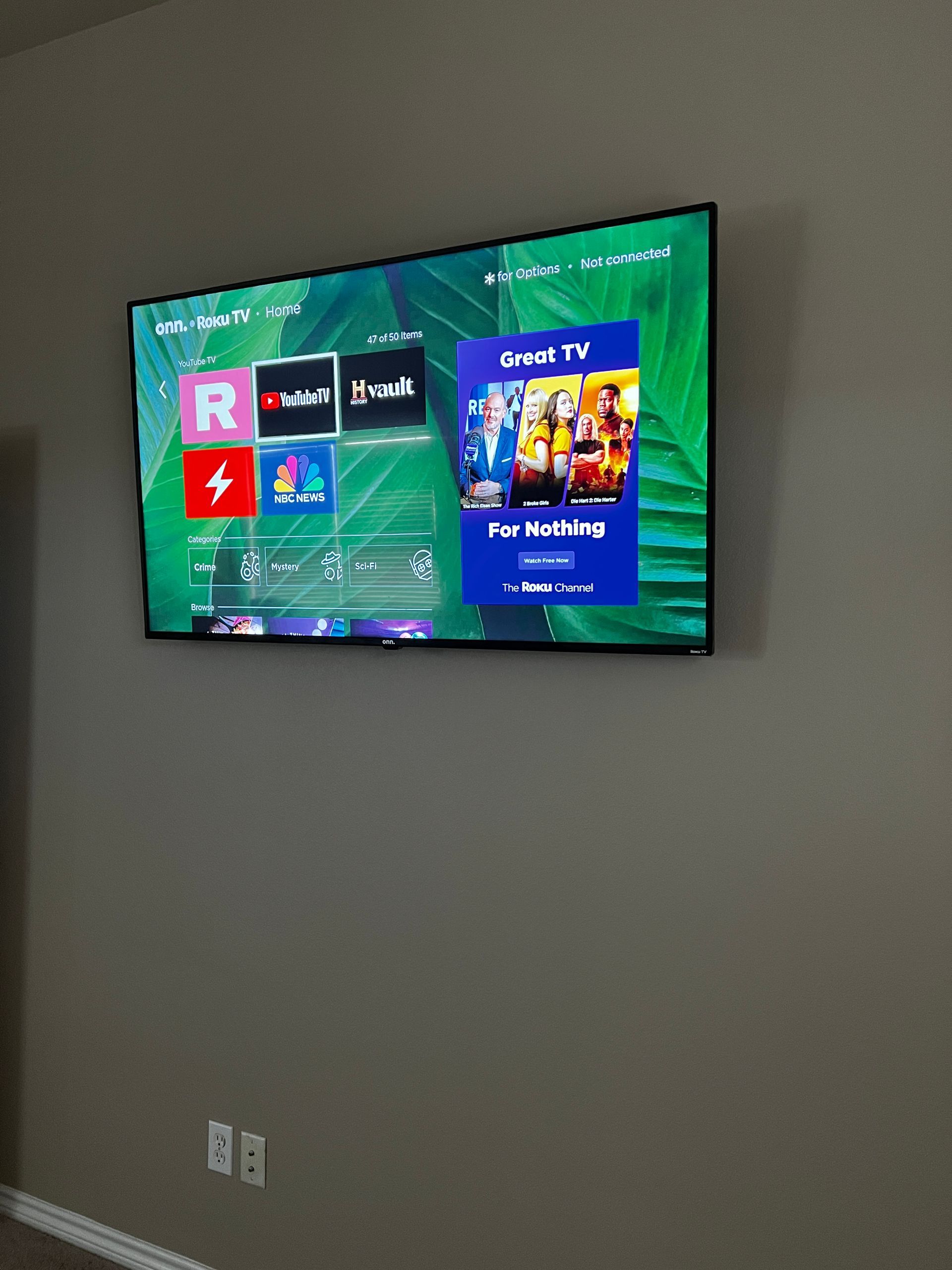 A flat screen tv is mounted on a wall and shows nbc tv