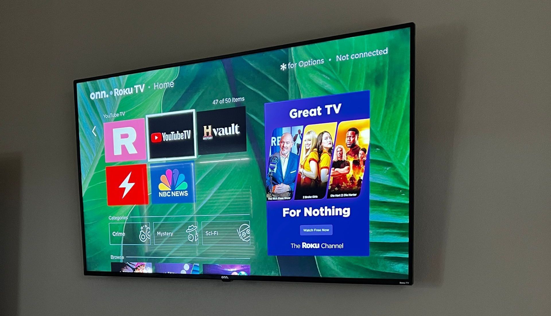 A flat screen tv is hanging on a wall and shows a screen that says great tv for nothing