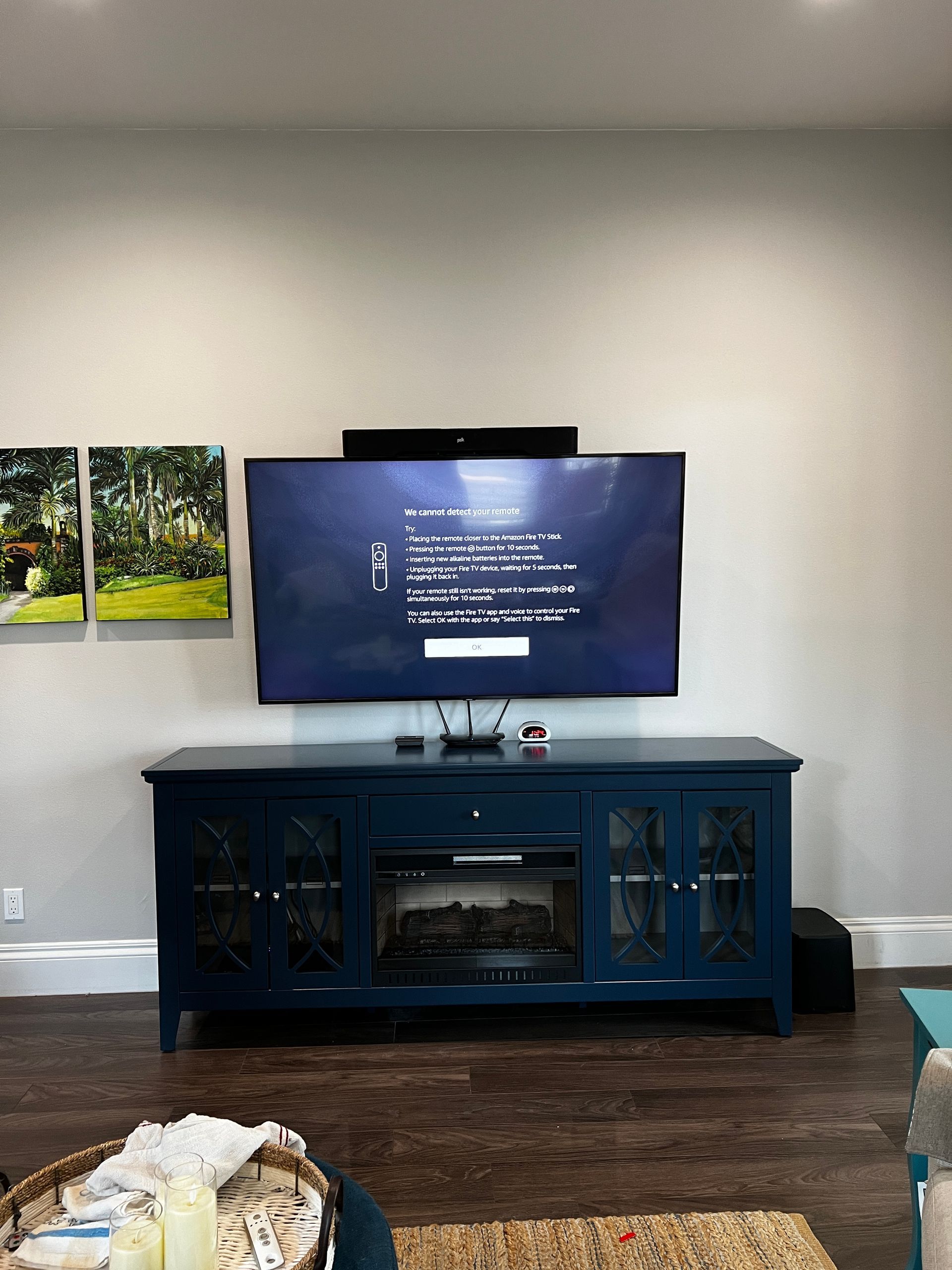 A living room with a flat screen tv mounted on the wall above a blue entertainment center.