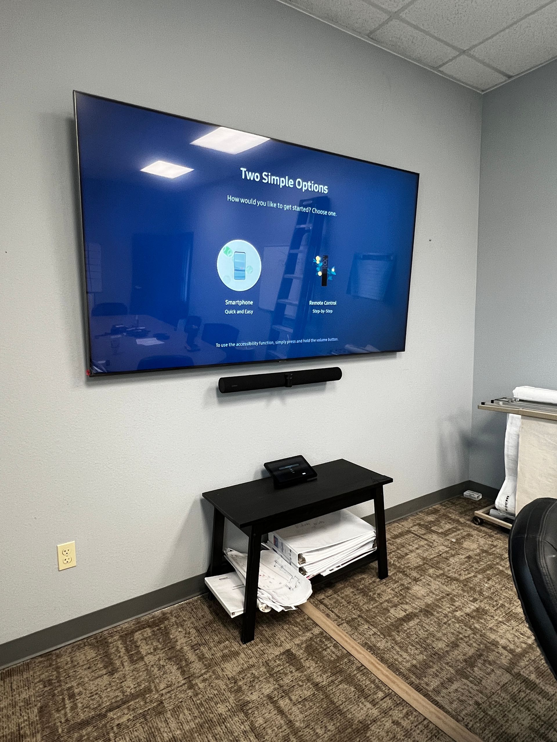 A large flat screen tv is hanging on a wall in a room.
