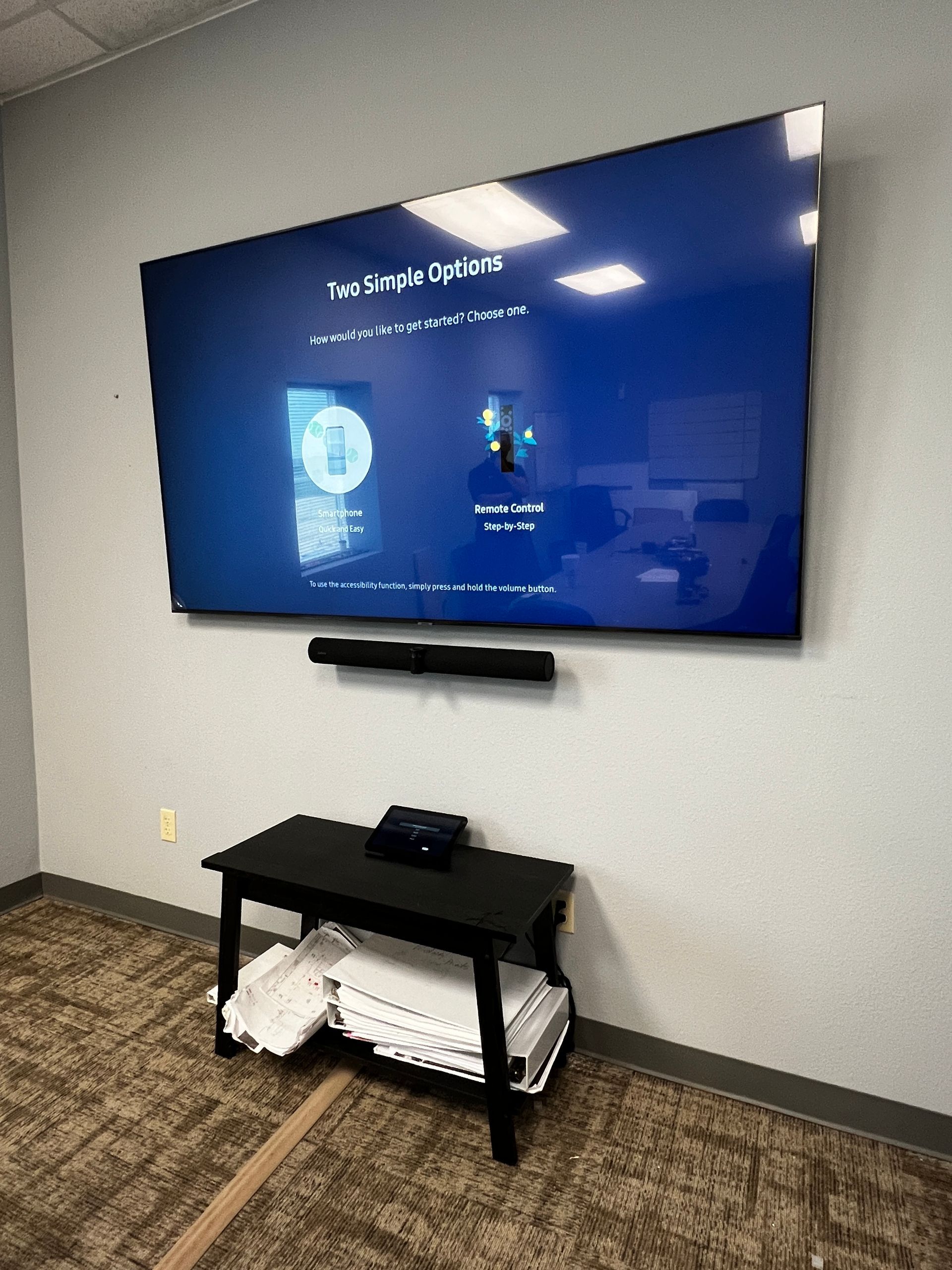 A large flat screen tv is hanging on a wall in a room.