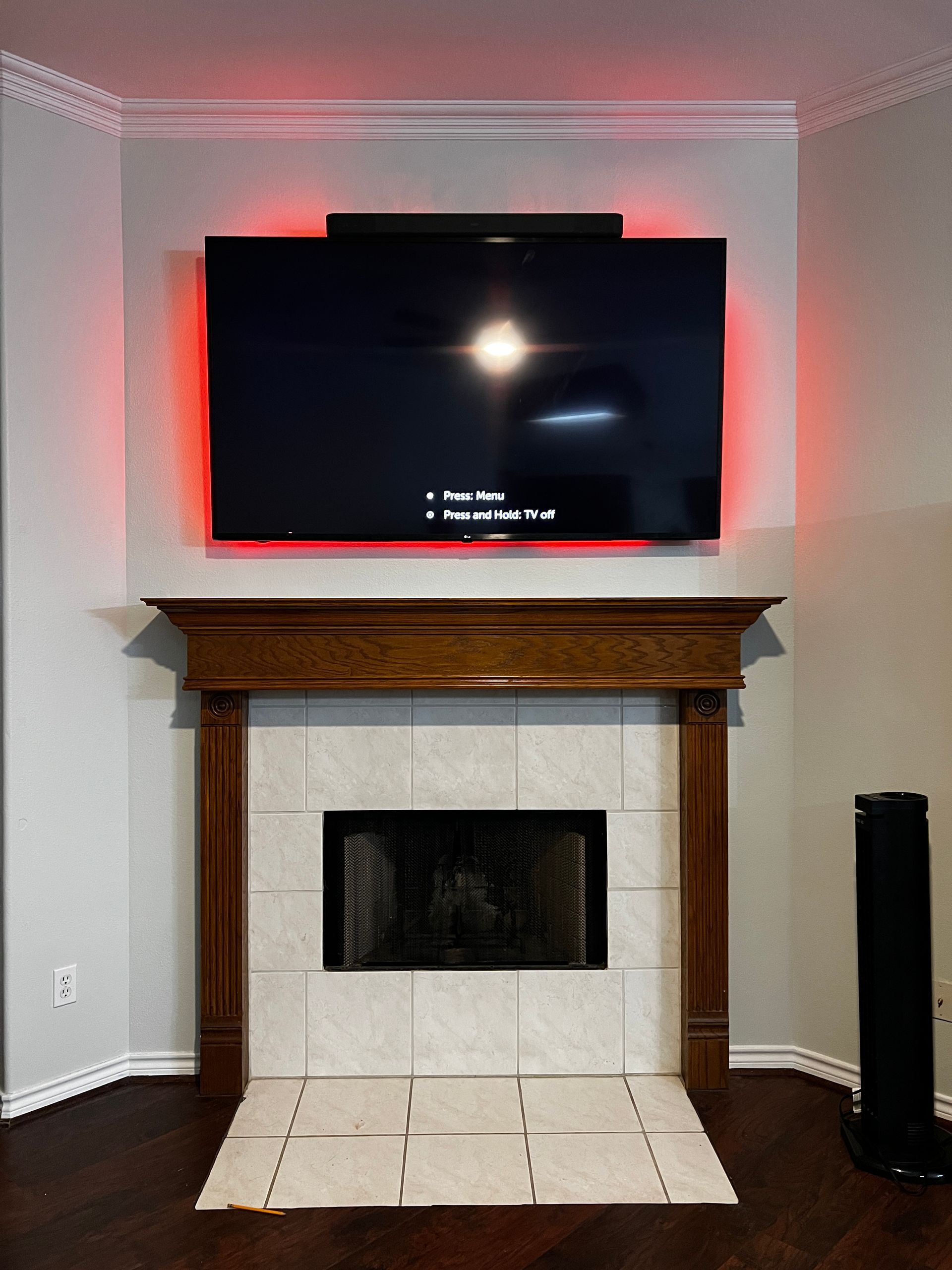 A flat screen tv is mounted above a fireplace in a living room.