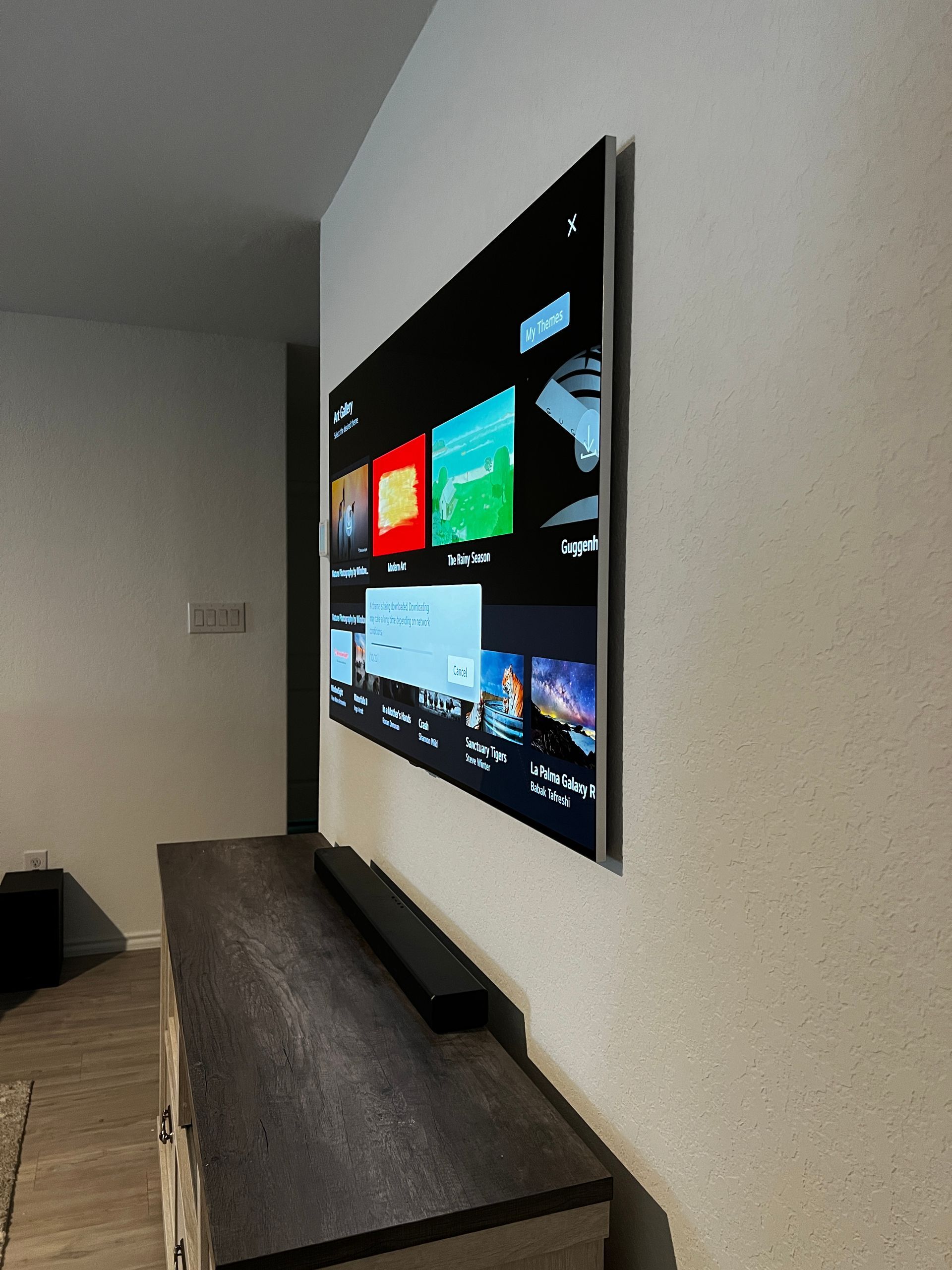 A flat screen tv is mounted on a wall above a dresser